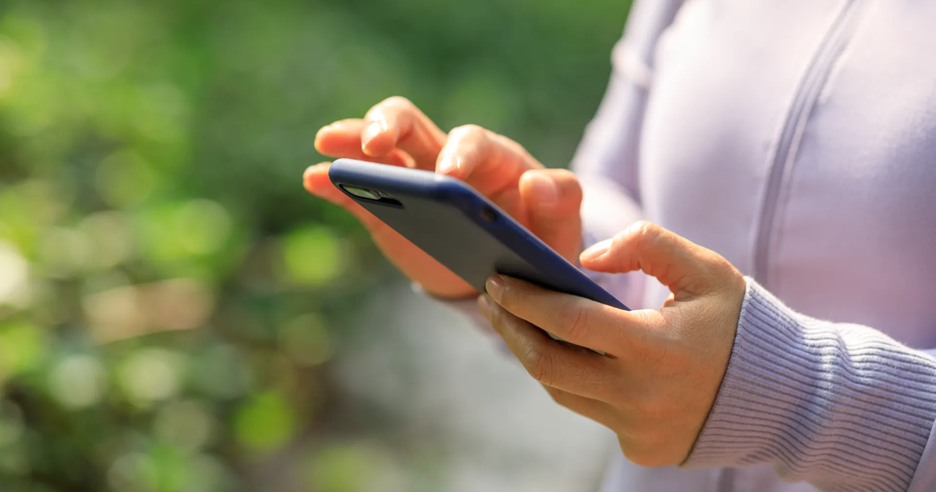 woman typing on phone outdoors in nature utc ()